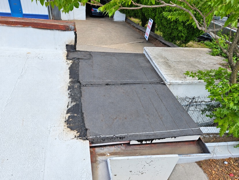 New modified bitumen membrane installed at the end of the roof at 2330 Columbia Pike to re-establish positive drainage, tying into the coated main roof
