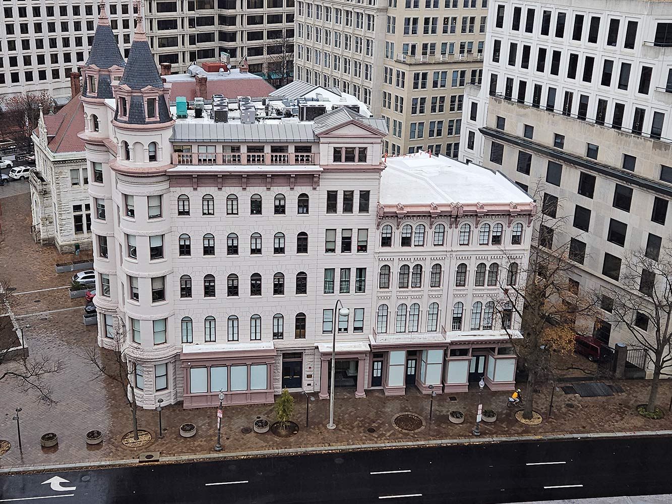 Aerial view of the historic turreted office building at 633 Pennsylvania Ave NW, Washington DC, with its white TPO roof and rooftop units